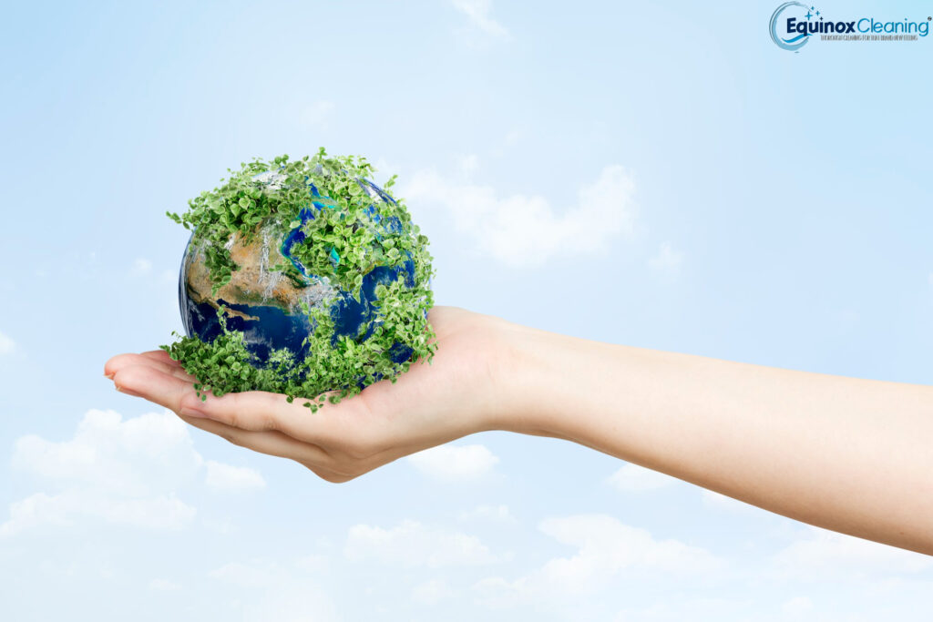 a hand holding a planet with plants growing on it